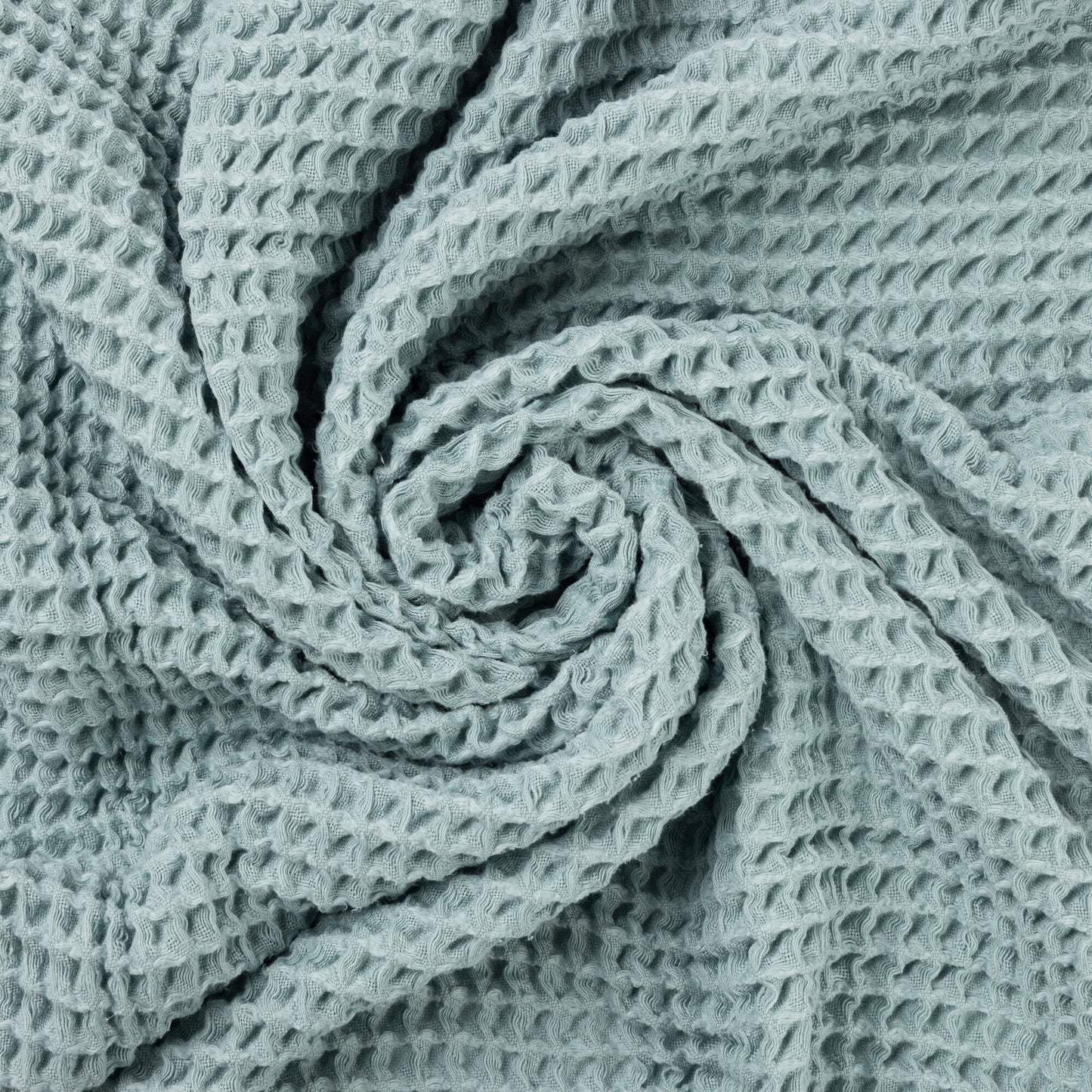 Close up photo of waffle texture of light blue baby blanket.