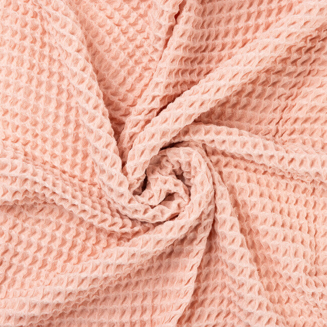 Close-up of a blush pink waffle textured fabric of a baby blanket