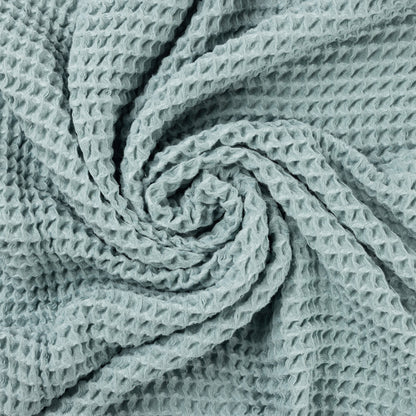 Close up photo of waffle texture of light blue baby blanket.