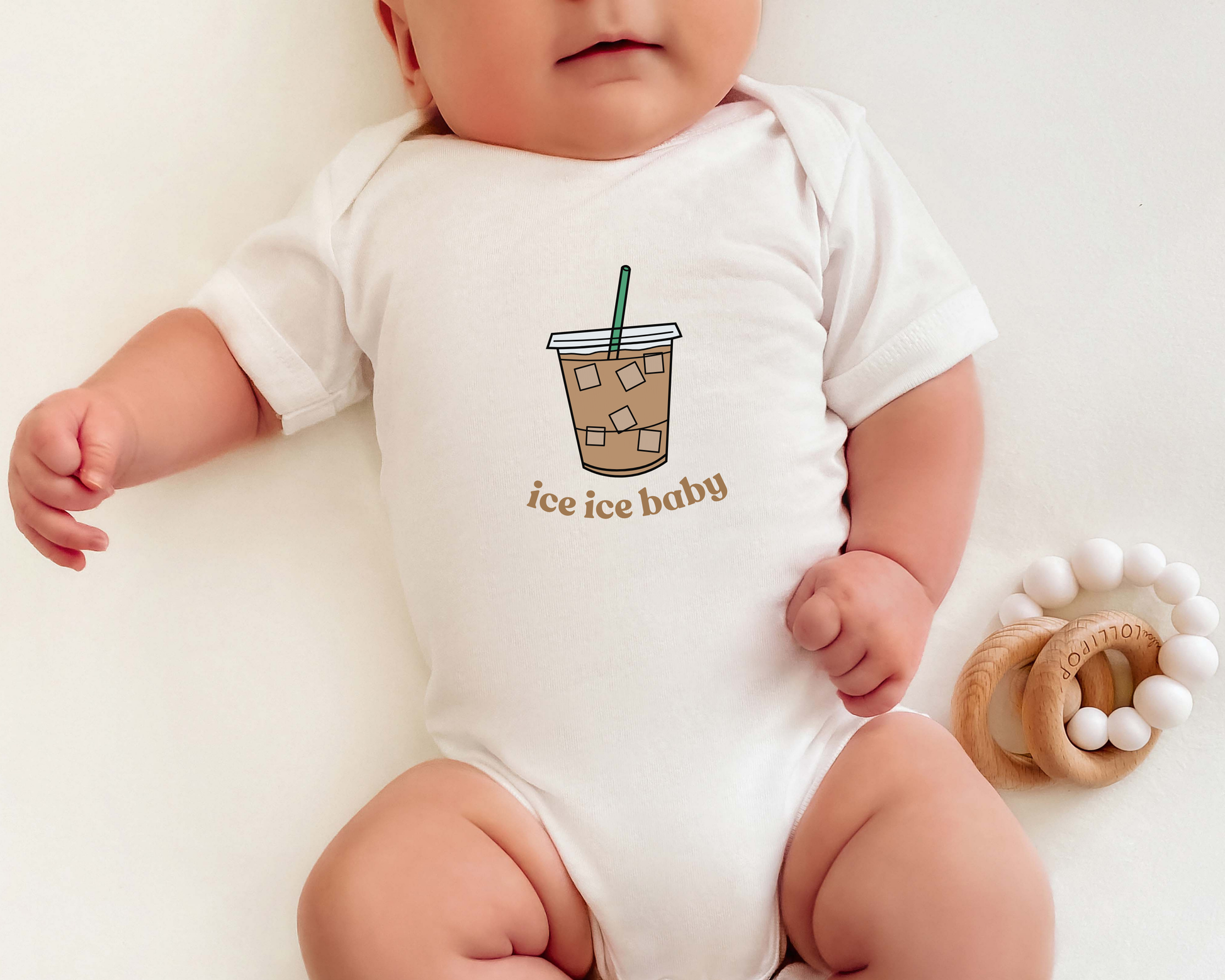 Baby wearing a white onesie with a graphic of an iced coffee cup and 'ice ice baby' text.