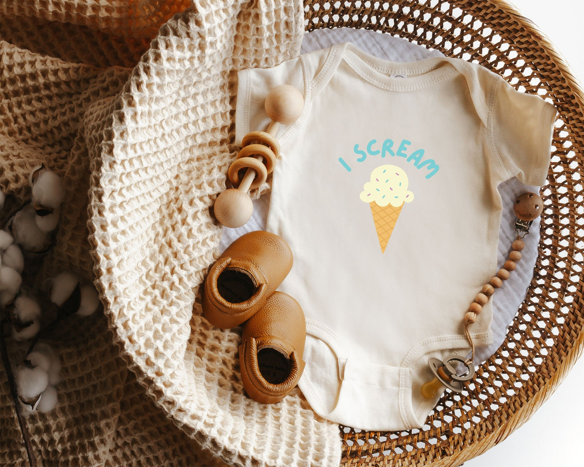 Baby onesie with ice cream cone design styled in a wicker basket.