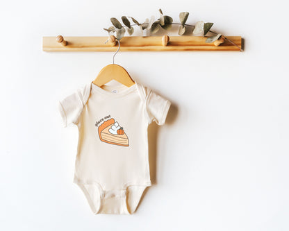 Short sleeve cotton baby onesie with a cute pumpkin pie drawing and the text "piece out" shown on a wooden hanger.