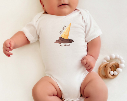 A baby wearing a short sleeve cotton onesie with a graphic of a chocolate melting ice cream cone and the text "having a meltdown".
