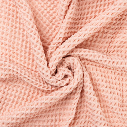 Close-up of a blush pink waffle textured fabric of a baby blanket
