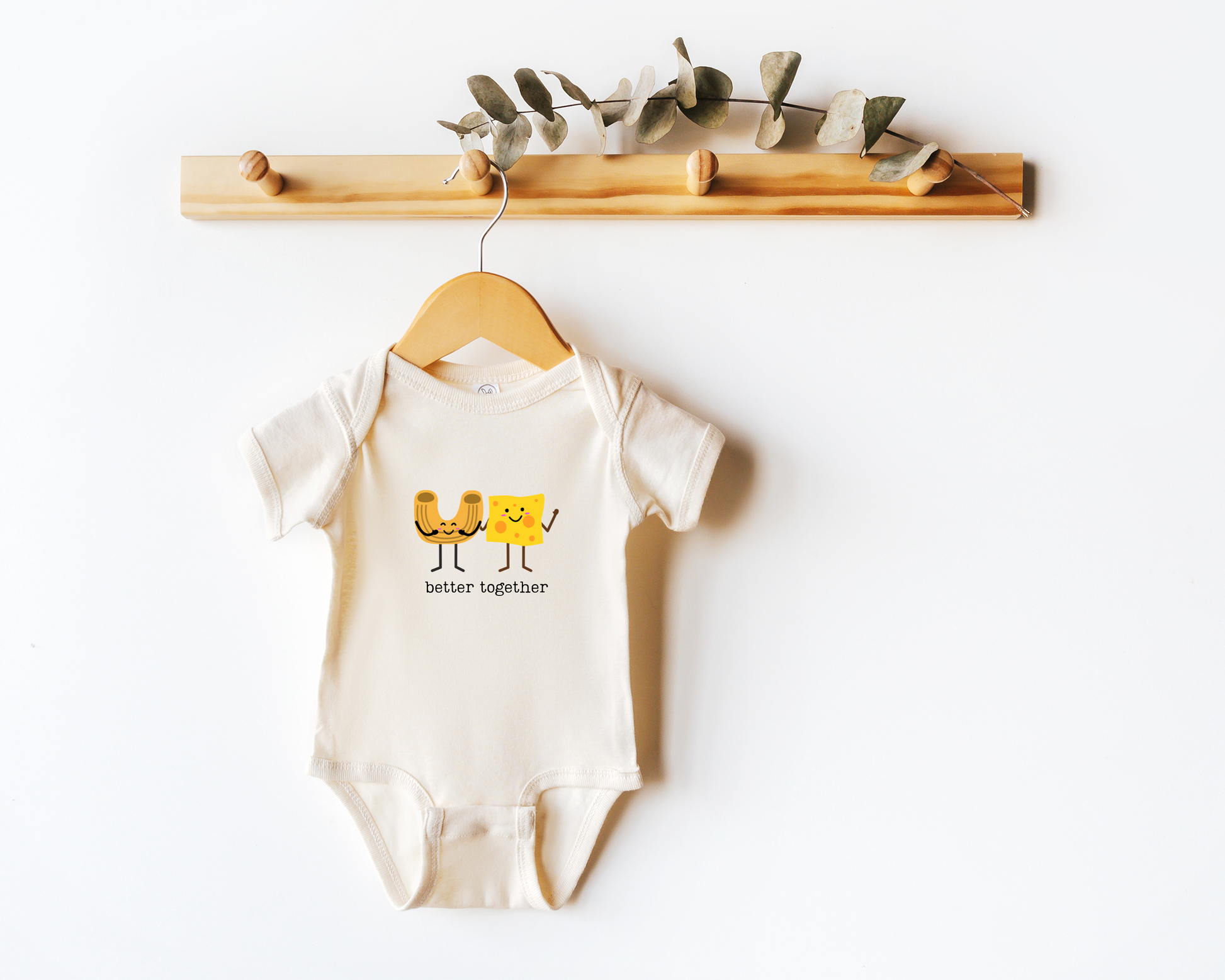 A short sleeve cotton baby onesie with a cute graphic of a macaroni noodle and cheese with the phrase "better together".