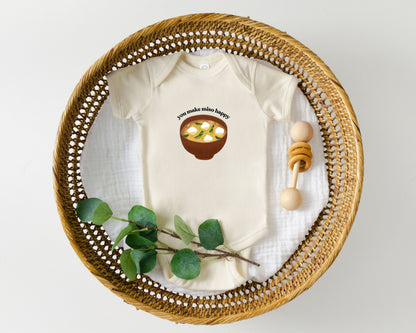 Short sleeve cotton baby onesie with a graphic of miso soup and the playful phrase "you make miso happy" displayed in a basket.